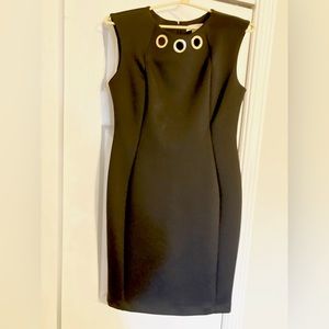 Calvin Klein size 6 PETITE mid length black dress with golden circle accents.